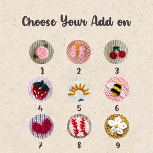 K&ouml;nnte beinhalten: Das Bild zeigt neun gestickte Aufn&auml;her mit verschiedenen Designs, darunter eine rosa Rose, ein Schmetterling, Kirschen, eine Erdbeere, eine Sonne, eine Biene, Herzen, ein Baseball und eine wei&szlig;e Blume. Der Text "Choose Your Add on" steht oben.