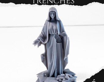 May include: A gray statue of a robed figure, standing on a base of pillows and debris. The statue has a serene expression and outstretched hands. The text "OUR LADY OF THE TRENCHES" is above the statue.
