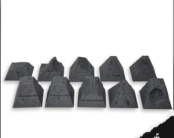 May include: A collection of ten gray miniature rock formations, each with a unique shape and texture. The rocks vary in size and design, suitable for tabletop gaming or model scenery. The rocks are arranged in a row against a white background.