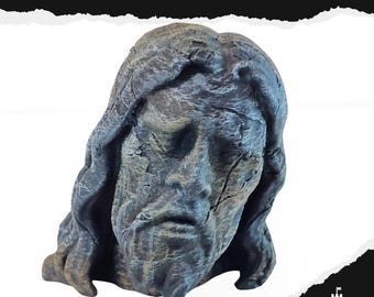 May include: A weathered, gray sculpture of a human head with long hair and a beard. The sculpture has a cracked surface and the text "FALLEN GOD" is above it. The logo "KEEP DESIGN" is in the bottom right corner.