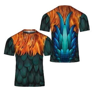 Puede incluir: Una camiseta de manga corta con un dise&ntilde;o de plumas colorido. La parte delantera de la camiseta muestra un patr&oacute;n de plumas verdes y naranjas, mientras que la parte trasera muestra plumas azules y turquesas. La camiseta tiene cuello redondo y corte regular.