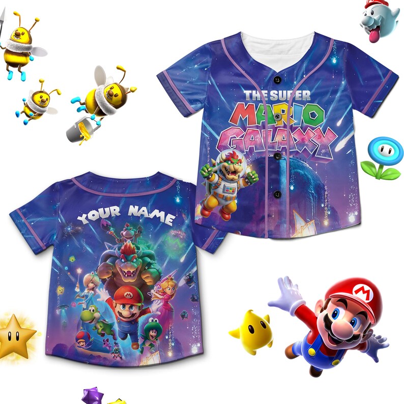 Puede incluir: Una camiseta de b&eacute;isbol azul con personajes y texto del videojuego "The Super Mario Galaxy". La parte delantera de la camiseta muestra el t&iacute;tulo del juego y Bowser. La parte trasera tiene el texto "YOUR NAME" encima de un gr&aacute;fico de Mario y otros personajes.