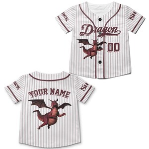 May include: White baseball jersey with burgundy pinstripes and accents. Features a cartoon dragon graphic and the word "Dragon" in script. The back of the jersey has the text "YOUR NAME".
