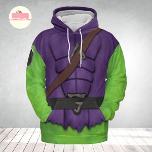 May include: A hooded sweatshirt featuring a purple and green design, with a brown strap across the chest. The sleeves are green, and the body of the sweatshirt is purple with a black belt and a green hem. The design resembles a costume.