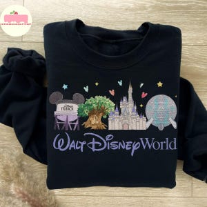 May include: Black sweatshirt with embroidered Disney World imagery: Cinderella's castle, Spaceship Earth, and the Tree of Life. The words "Walt Disney World" are embroidered in a purple script, a perfect gift for Disney fans.