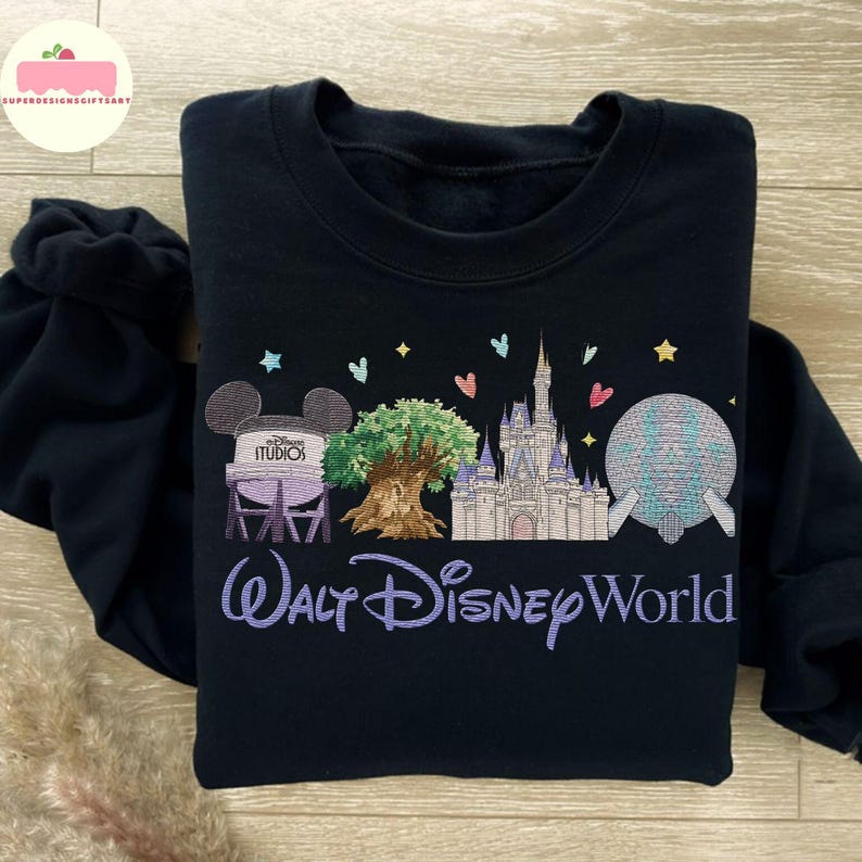May include: Black sweatshirt with embroidered Disney World imagery: Cinderella's castle, Spaceship Earth, and the Tree of Life. The words "Walt Disney World" are embroidered in a purple script, a perfect gift for Disney fans.