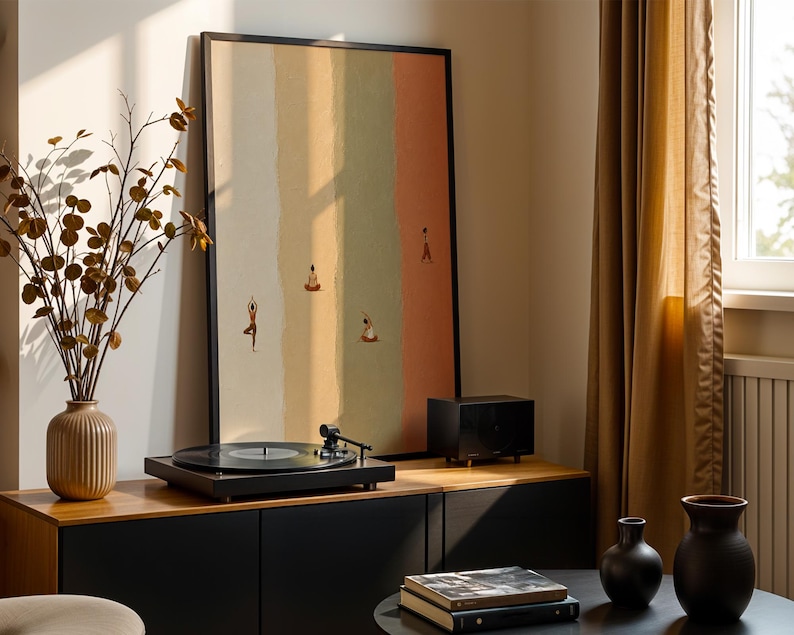 May include: A framed vertical wall art print featuring four small figures in various yoga poses against a background of four vertical color-blocked stripes in shades of cream, yellow, sage green, and terracotta, enclosed in a thin black frame.