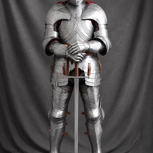 Handmade medieval full plate knight armor suit crafted from polished steel, featuring a Gothic-style helmet, articulated body armor, gauntlets, leg armor, and leather straps, displayed holding a medieval sword against a gray backdrop.