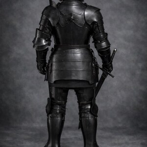 May include: A full suit of black medieval armor, including a helmet, shoulder guards, chest and back plates, and leg protection. A sword is held at the side. The Medieval Store logo is visible in the upper right corner.