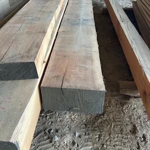 May include: A handmade, wooden cutting board with a natural finish. The board features a live edge on one side and a smooth, rectangular shape. It is approximately 18 inches long and 12 inches wide.