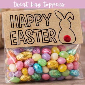 Könnte beinhalten: Ein klarer Zellophanbeutel gefüllt mit bunten Ostersüßigkeiten. Der Beutel ist mit einem braunen Papieranhänger mit der Aufschrift "HAPPY EASTER" in schwarzen Buchstaben und einer Hasenkontur versehen. Die Süßigkeiten umfassen Geleebohnen und folienverpackte Pralinen.