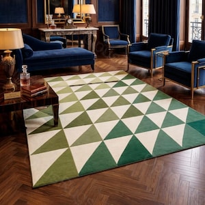 May include: A luxurious living room featuring a geometric patterned rug in shades of green and white. The room includes blue velvet furniture, gold accents, and dark wood paneling, creating an elegant and sophisticated atmosphere.