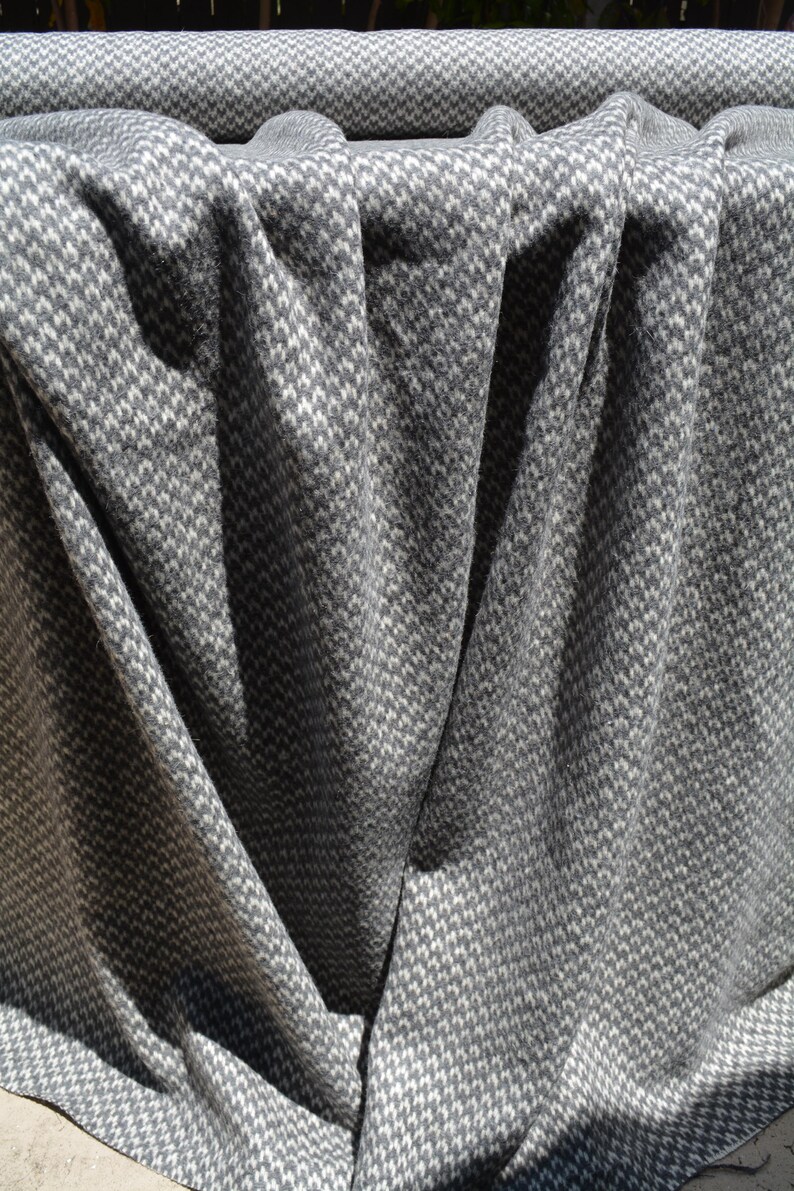 a close-up view of a crumpled gray and white patterned fabric, with a textured and wrinkled appearance.