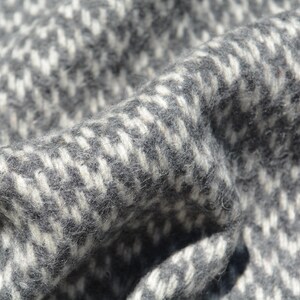 A close-up view of a textured fabric with a black and white checkered pattern.