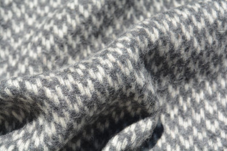 A close-up view of a textured fabric with a black and white checkered pattern.