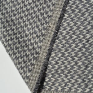 a close-up view of a gray and white checkered fabric, with a textured and patterned appearance.