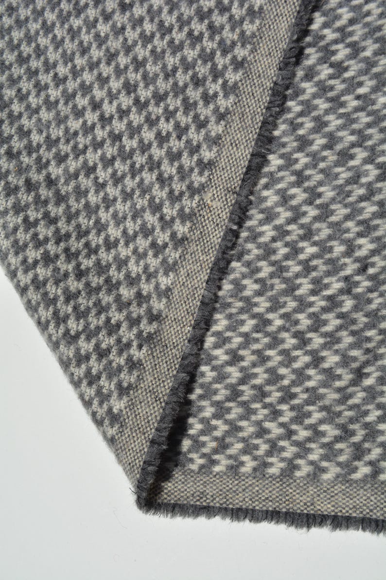 a close-up view of a gray and white checkered fabric, with a textured and patterned appearance.