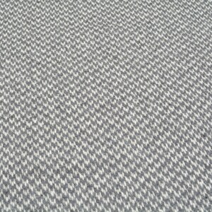 a close-up view of a textured surface with a repeating pattern of small white and gray squares or rectangles, creating a visually striking and intricate design.