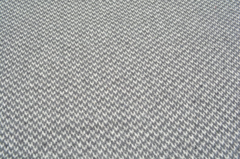 a close-up view of a textured surface with a repeating pattern of small white and gray squares or rectangles, creating a visually striking and intricate design.