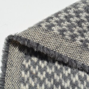 a close-up view of a textured fabric with a gray and white checkered pattern.