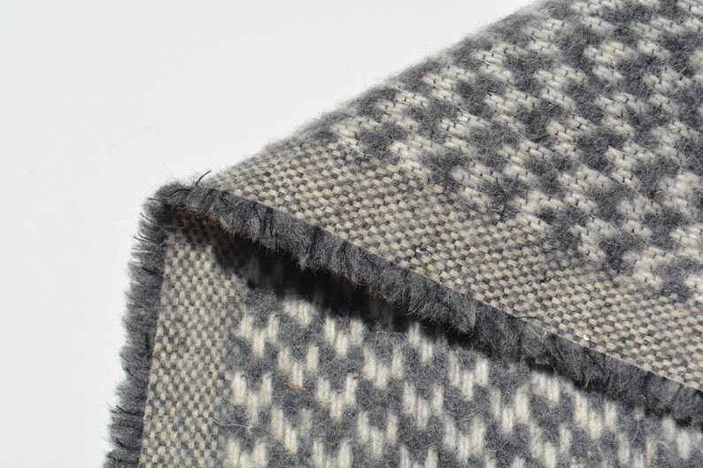 a close-up view of a textured fabric with a gray and white checkered pattern.