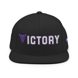 May include: Black flat-brimmed baseball cap with the word "VICTORY" in white block letters outlined in purple. A purple geometric design is above the word "VICTORY". The cap has a structured fit and a curved brim.