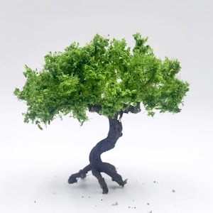 Peut inclure: Petit modèle d'arbre avec un tronc torsadé brun foncé et un feuillage vert vif. L'arbre a un auvent plein et texturé et est placé sur un fond blanc uni. Cet arbre miniature est probablement pour un modélisme.