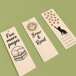 Puede incluir: Tres marcapáginas color crema con ilustraciones y texto en negro. Uno dice "Five more pages" con un gato durmiendo sobre libros. Otro dice "Brew & Read" con un diseño de taza de café. El tercero muestra un gato alcanzando granos de café.