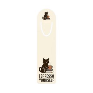 Puede incluir: Marcapáginas crema con una ilustración de un gato negro sosteniendo una taza de café, sentado sobre libros. El texto "ESPRESSO YOURSELF" está debajo del gato. Una versión más pequeña del gato y la taza de café está en la parte superior. Se adjunta una cinta blanca.