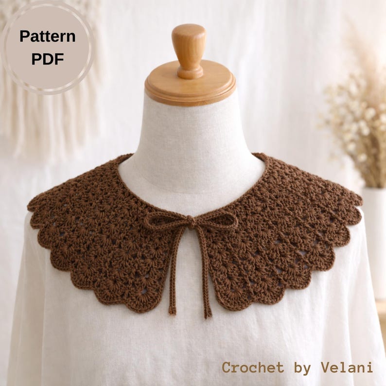May include: A brown crochet collar with a scalloped edge and a bow tie closure. The collar is displayed on a mannequin and is labeled "Pattern PDF" and "Crochet by Velani". The collar is a handmade accessory.