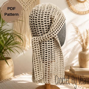 May include: A beige crochet head covering featuring an open grid pattern and a long, dangling side tie. The item is displayed on a dark gray mannequin head. A circular brown graphic in the upper left corner contains the text PDF Pattern.