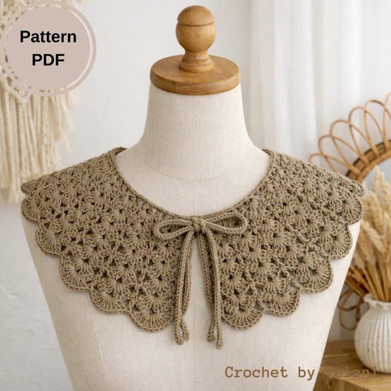 May include: A crocheted collar in a neutral tan color, displayed on a mannequin. The collar features a scalloped edge and a delicate, openwork design. A bow tie detail is at the front. The text "Pattern PDF" is in a circle at the top left.