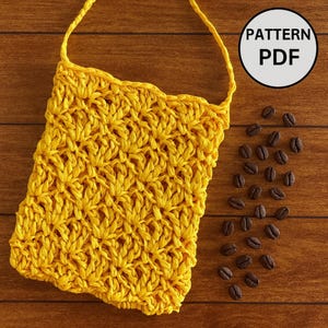 K&ouml;nnte beinhalten: Eine gelbe geh&auml;kelte Tasche mit Trageriemen und strukturiertem Muster. Die Tasche ist rechteckig mit einem gewellten oberen Rand. Die Worte "PATTERN PDF" befinden sich in einem wei&szlig;en Kreis. Kaffeebohnen sind auf einer Holzoberfl&auml;che verstreut.