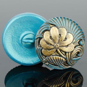 Botón redondo de cristal checo con forma de flor: aguamarina con detalles dorados antiguos. Se vende por unidad. 18 mm