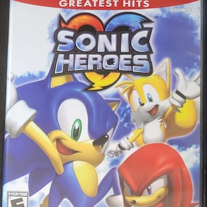 May include: A PlayStation 2 video game case for "Sonic Heroes." The cover features Sonic the Hedgehog, Tails, and Knuckles. The game title is in large, bold letters with a blue and orange design. The ESRB rating is visible.