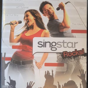 May include: Singstar Rocks! video game case for PlayStation 2. The cover features a woman and a man singing into microphones, with the game's title in a speech bubble. The case includes the names of artists like Gwen Stefani and Coldplay.