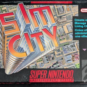 May include: SimCity Super Nintendo game box. The box features the game's title in large, red and orange letters with a cityscape background. The Super Nintendo Entertainment System logo is at the bottom, with the Nintendo logo at the top.