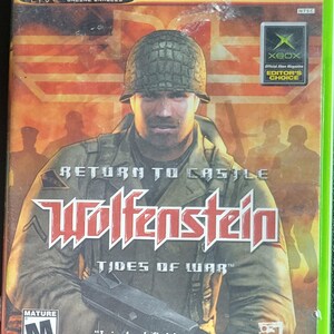 Puede incluir: Caja de juego de Xbox para "Return to Castle Wolfenstein: Tides of War". La portada presenta a un soldado con casco sosteniendo un arma. El título del juego está en letras rojas grandes y estilizadas. La caja es verde con el logotipo de Xbox y el texto "Live Online Enabled".