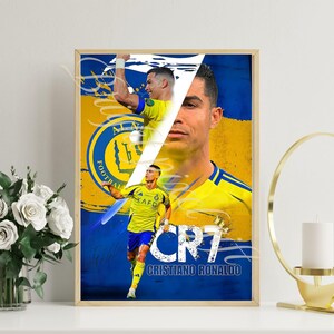 May include: Framed poster featuring Cristiano Ronaldo in a yellow and blue soccer uniform. The poster has a split design with multiple images of Ronaldo, the text "CR7" and "Cristiano Ronaldo". The background is yellow and blue.
