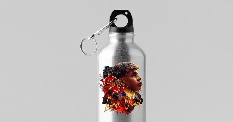May include: A silver water bottle with a black cap and a silver carabiner clip. The bottle features a colourful graphic of a footballer with the name "Lamine Yamal" in gold script.