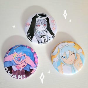 May include: Three round anime-style pinback buttons. One features a nun-like character with red eyes and Japanese text. Another shows a blue-haired character forming a heart with their hands, with the word "AWAH!" below. The third button has a smiling character with blue hair and a bunny.