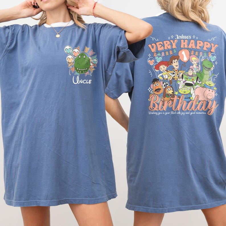 May include: Blue t-shirt with a white collar featuring a cartoon dinosaur and the word "Uncle". The back of the shirt has a graphic with the text "Very Happy Birthday" and various cartoon characters.