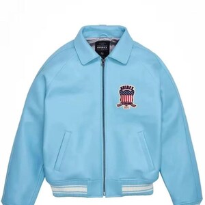 Puede incluir: Chaqueta azul claro con cierre de cremallera, cuello y bolsillos laterales. Los pu&ntilde;os y el dobladillo tienen un ribete a rayas blanco y azul claro. Un emblema con la palabra "AVIREX" y un dise&ntilde;o rojo, blanco y azul est&aacute; en el pecho.