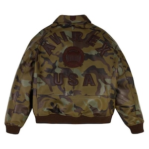 Pu&ograve; includere: Giacca in pelle con motivo mimetico con la scritta "AVIREX USA" sul retro. La giacca presenta colletto, polsini e orlo marroni e un'emblema marrone sopra il testo "USA". Il motivo mimetico utilizza tonalit&agrave; di verde, marrone e beige.