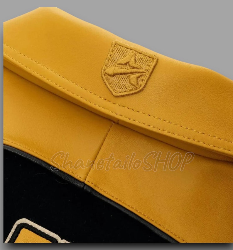May include: Close-up of a yellow leather accessory with a stitched emblem. The accessory has a black interior and a contrasting white trim. The text "Sharetailo SHOP" is visible.