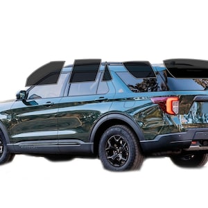May include: A dark green SUV with black wheels and tinted windows. The vehicle has a sleek design and is set against a white background. The SUV has a black roof rack and black side steps.