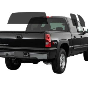 May include: Black pickup truck with tinted windows. The truck has a silver bumper and wheels. The word "Silverado" is visible on the tailgate. The truck is on a white background.