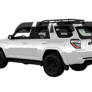 May include: A white SUV with black wheels and tinted windows. The vehicle has a roof rack and is viewed from a side angle. The tires are black, and the windows are tinted dark grey.