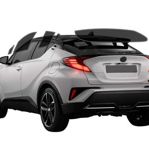 May include: A silver compact SUV with black accents, including the roof, wheels, and trim. The vehicle has tinted windows and a rear spoiler. The taillights are red, and the car is set against a white background.