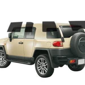 May include: A beige SUV with tinted windows, a spare tire on the back, and black accents. The vehicle has silver wheels and a black bumper. The windows are tinted with a dark film.